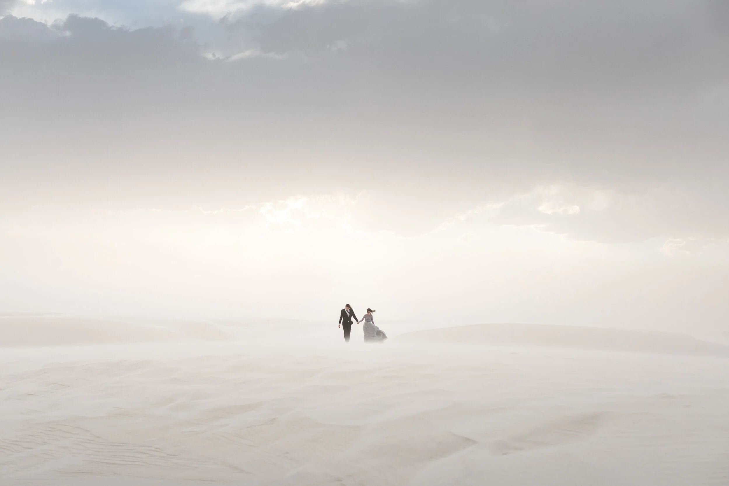 Couple walking in a foggy desert landscape