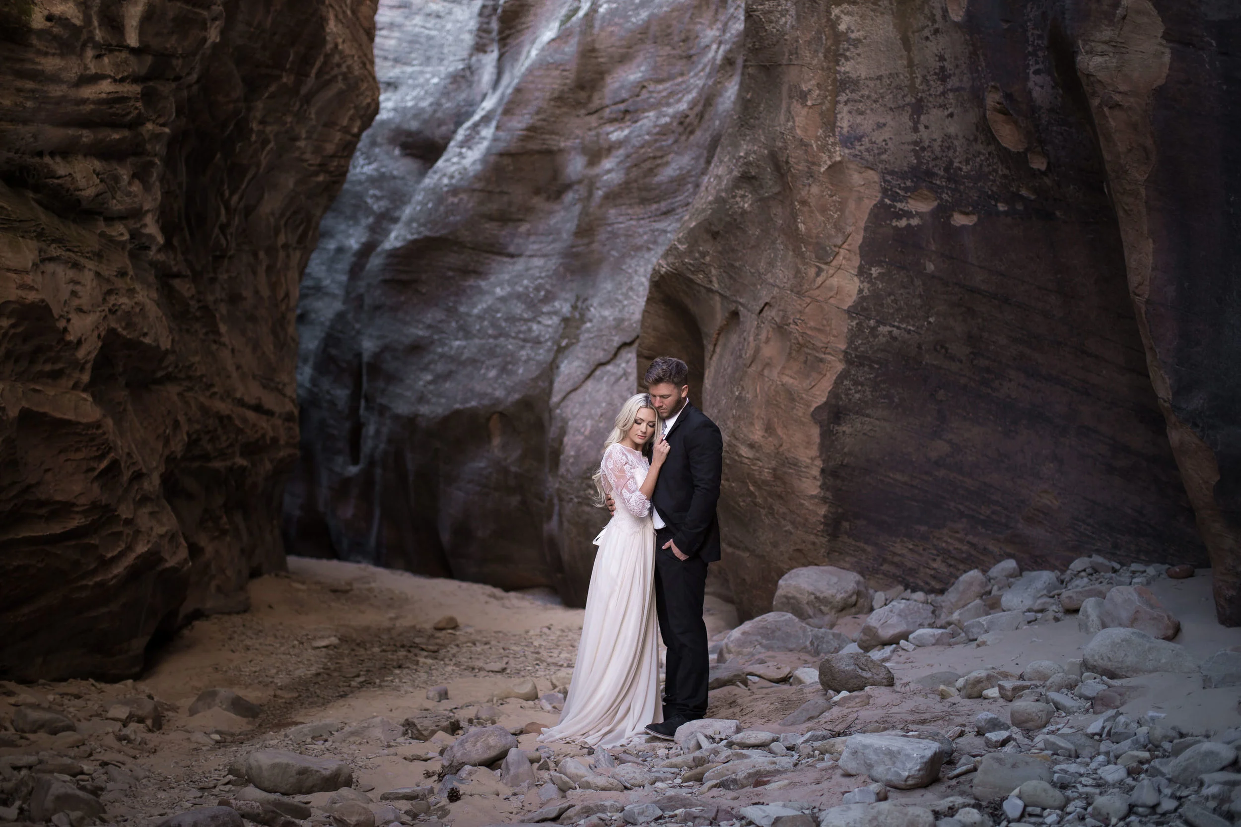 Bride and groom embrace inside a rocky canyon
