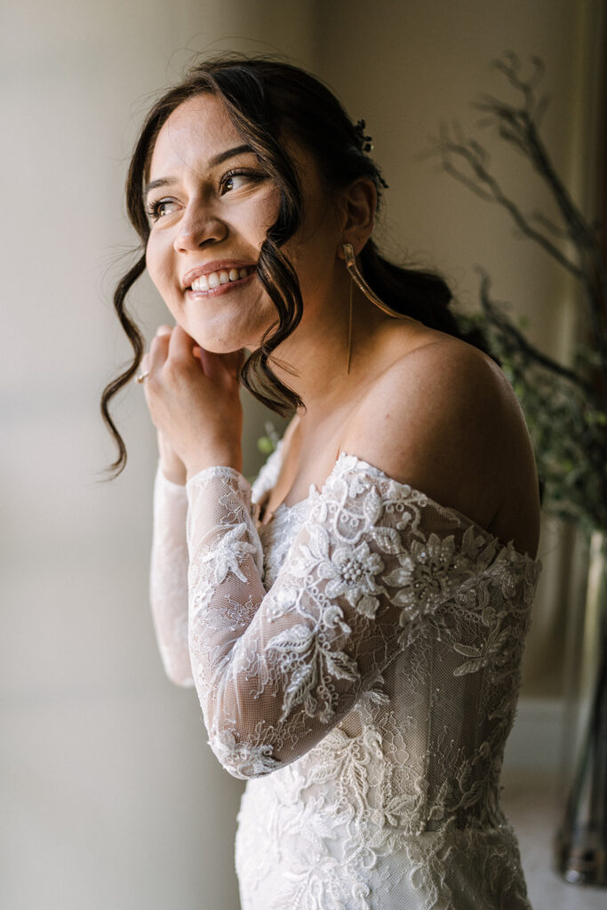 Bride putting on earrings at Gordon Springs
