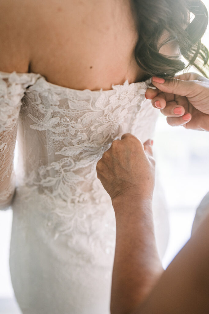 bride getting zipped into dress