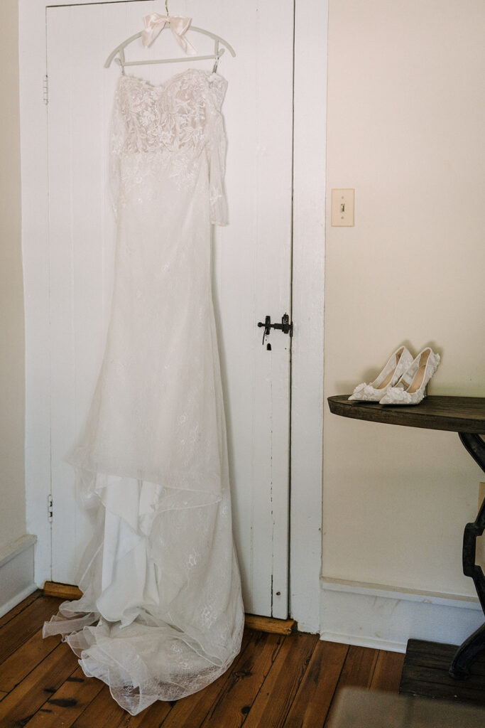 bridal gown hanging from wall at the start of a wedding day