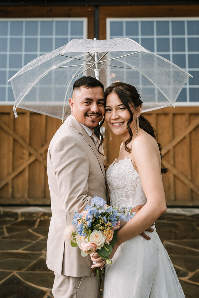 rainy day wedding portrait with clear umbrella