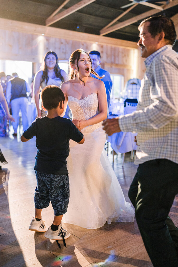 Bride dancing with a child on her wedding day